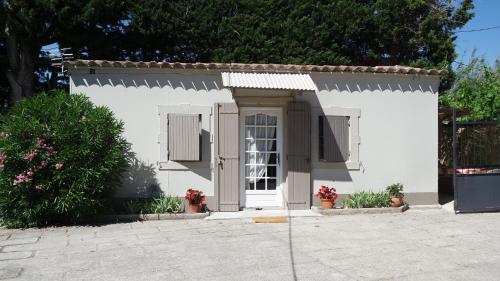 a small white house with a white door at Mas Grimaud - Gîte- Studio et chambres d'hôtes familiales in Eygalières