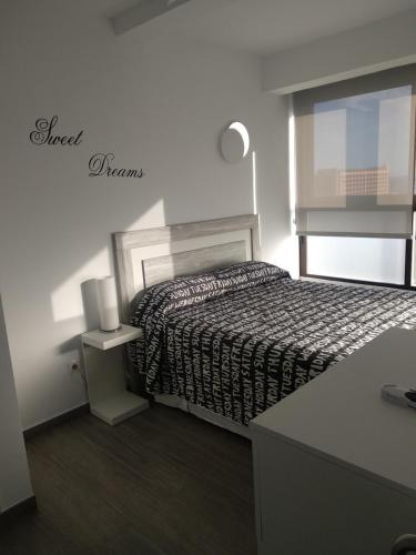 ein Schlafzimmer mit einem Bett und einem Schreibtisch mit einer Lampe in der Unterkunft Aloha Playa 1217 in Benalmádena