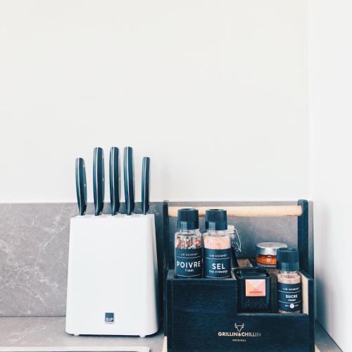 a counter with a knife block and bottles of sauce at Penthouse La Naturale zeezicht in Zeebrugge