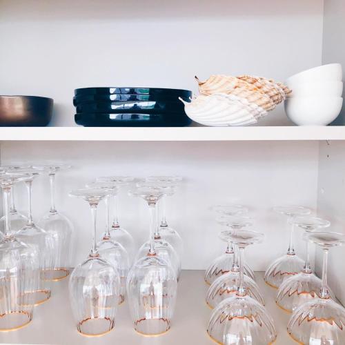 a bunch of wine glasses sitting on a shelf at Penthouse La Naturale zeezicht in Zeebrugge