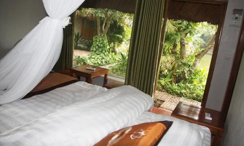 a bedroom with a bed and a large window at Thai Binh Garden in Thái Bình
