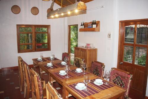 a dining room with a long wooden table and chairs at Thai Binh Garden in Thái Bình
