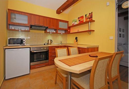 cocina con mesa de madera, mesa y sillas en Apartmán pri jazere, en Ružomberok