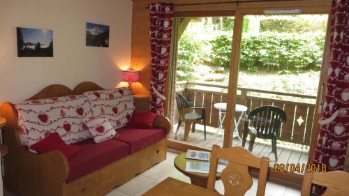 sala de estar con sofá y balcón en Alpine Lodge 2, en Les Contamines-Montjoie