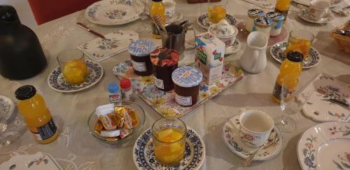 a table topped with plates and cups of orange juice at La Ferme De Saint Julien in Charleville-Mézières