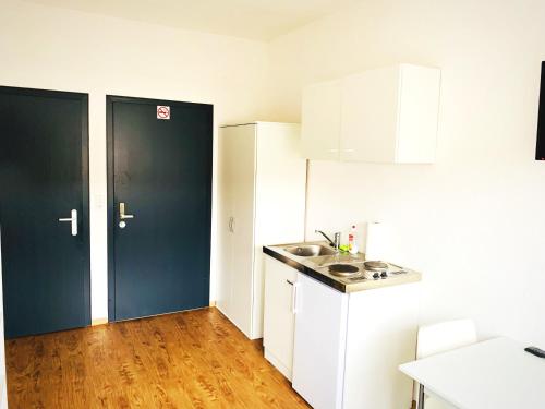 una cocina con armarios blancos y una puerta negra en Living @ Klassvilla - Weserwehr No. 6 en Bremen