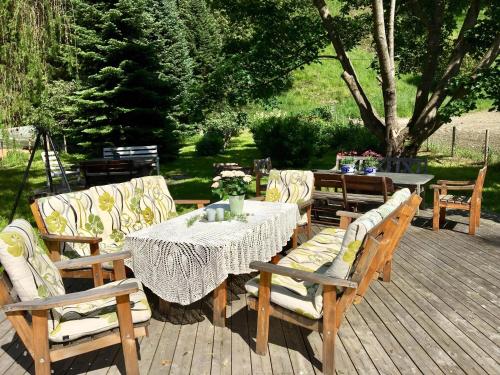 a wooden table and chairs on a wooden deck at Skjeggestad Gjestehus in Ringebu