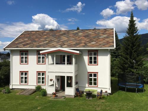 uma casa branca com um telhado vermelho em Skjeggestad Gjestehus em Ringebu