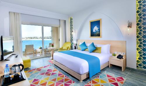 a hotel room with a bed and a view of the ocean at Hotelux La Playa Alamein in El Alamein