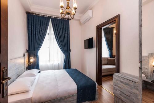 a bedroom with a bed with blue curtains and a mirror at Element Garden in Istanbul