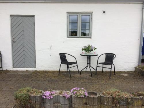 uma mesa e cadeiras em frente a uma casa branca em Dalsgaard em Vojens