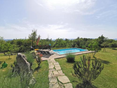 a swimming pool in a grassy field with a yard at Holiday Home Villa Mavrici in Buzet