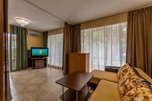 a living room with a couch and a tv at Guest House Domashniy Uyut in Gelendzhik