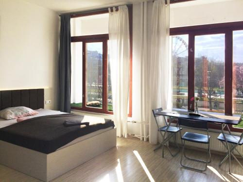 um quarto com uma cama, uma secretária e janelas em Zoom-Budapest Apartments em Budapeste