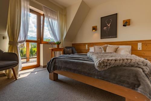 a bedroom with a bed and a large window at Willa Rychlina in Zakopane