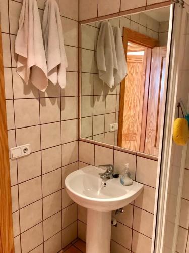 a bathroom with a sink and a mirror and towels at Casa de familia in Calpe