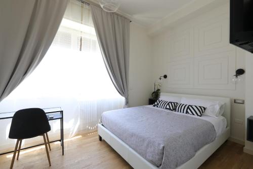 a bedroom with a bed and a desk and a window at B&B Dimora del Duomo in Benevento