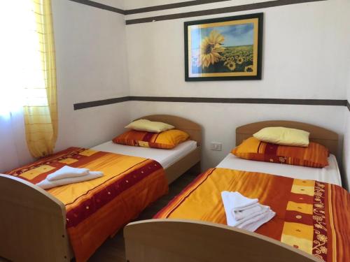 ein Schlafzimmer mit zwei Betten und einem Bild an der Wand in der Unterkunft VILLA DIVNA in Labin