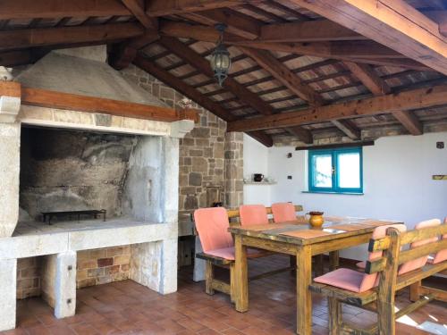 ein Esszimmer mit Tisch und Kamin in der Unterkunft VILLA DIVNA in Labin
