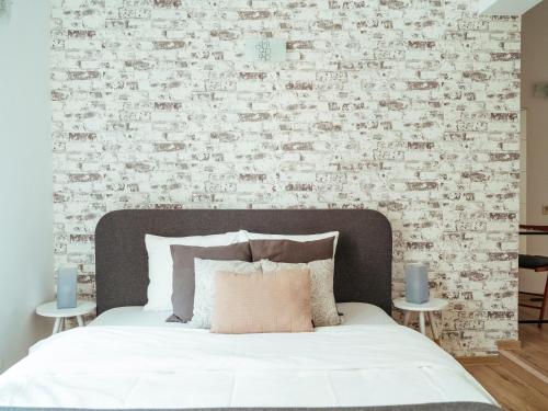 een slaapkamer met een bed en een bakstenen muur bij Tonitza Old Town - Double Studio in Boekarest