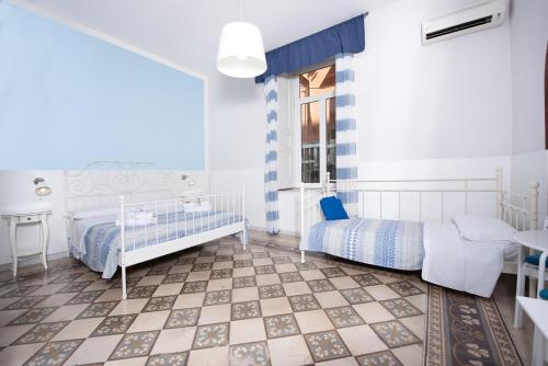 a bedroom with two beds and a table and a window at Napoli Experience in Naples