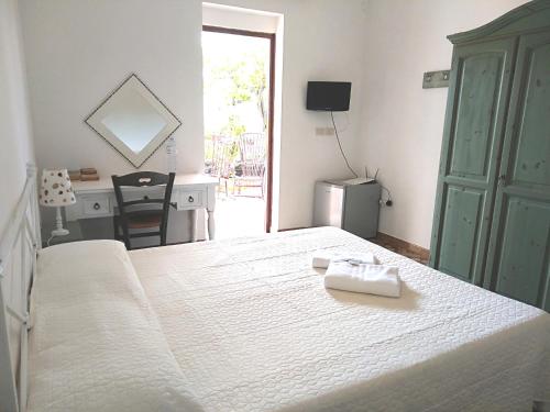 a bedroom with a white bed with a desk and a desk at La Via Del Mare in Arenella