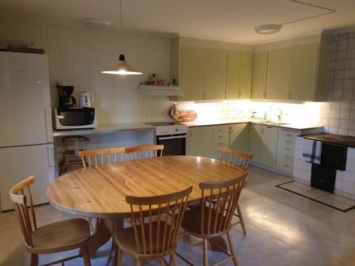 eine Küche mit einem Holztisch und Stühlen in der Unterkunft WESTERQVARN in Mölntorp