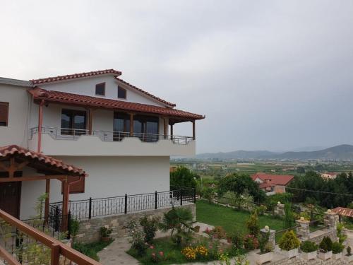 a white house with a balcony and a yard at Vila Palma in Berat