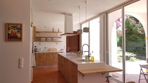 a kitchen with a sink and a large window at Villa Sequoia - Beach and Lake Private Holidays in Troia