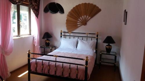 a bedroom with a bed with a fan on the wall at Casa do Costa in Fajã