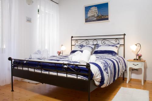a bedroom with a bed with blue and white sheets at House Corte dei Matte' in Rovinj