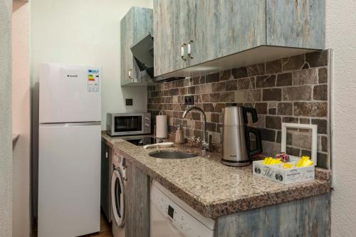 a kitchen with a sink and a white refrigerator at Element Garden in Istanbul
