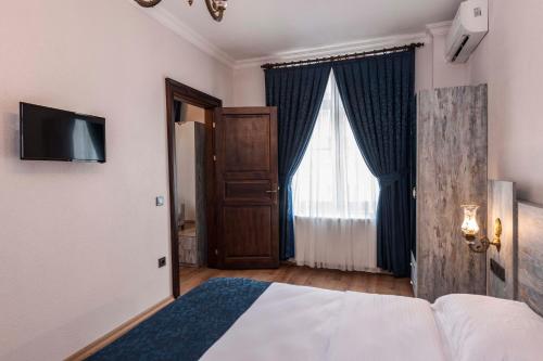 a bedroom with a bed and a television and a window at Element Garden in Istanbul