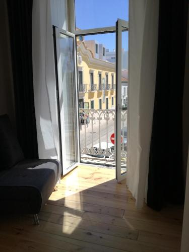 an open door to a balcony with a view of a building at Temple Suites Guesthouse in Portimão