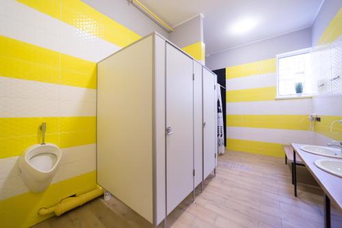 a bathroom with a toilet and two sinks and a urinal at HOTEL Bee Station in Kyiv