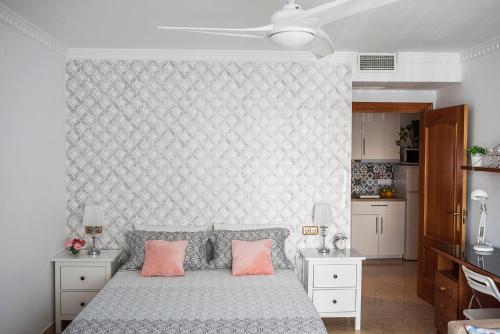 een slaapkamer met een bed met 2 roze kussens bij Suite Mirando al Guadiana in Ayamonte
