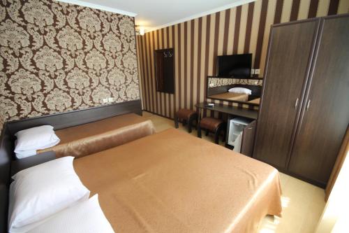 アドレルにあるヴィラ ボッサのベッド2台とデスクが備わるホテルルームです。