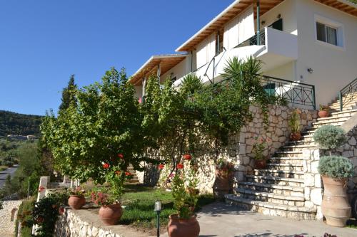 a house with a bunch of potted plants on the stairs at Althea Studios Lefkada in Agios Nikitas