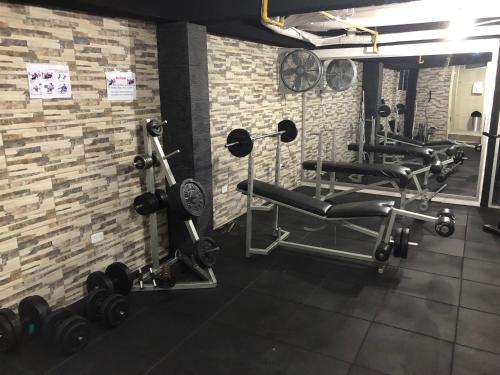 a gym with tread machines and a brick wall at Hotel La Cascada - Lago Agrio in Nueva Loja