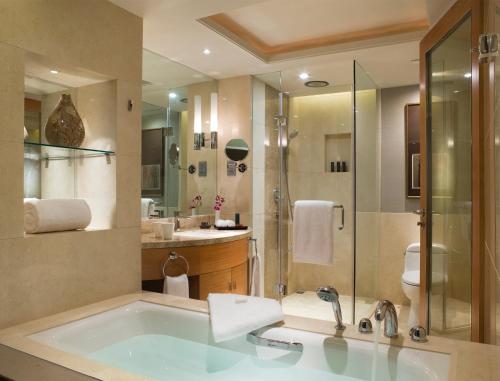 a bathroom with a tub and a shower and a sink at Wanda Realm Beijing in Beijing