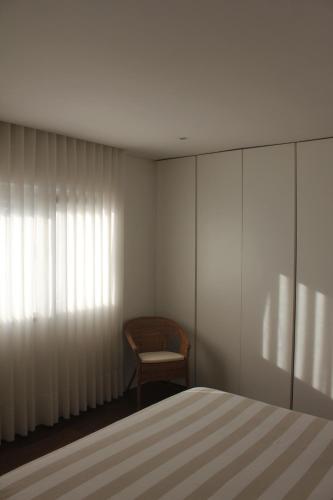 a bedroom with a bed and a chair at Manuel Tiago Pereira in Braga