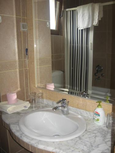 a bathroom with a white sink and a mirror at Apartments and Rooms Levantin Inn in Sveti Stefan
