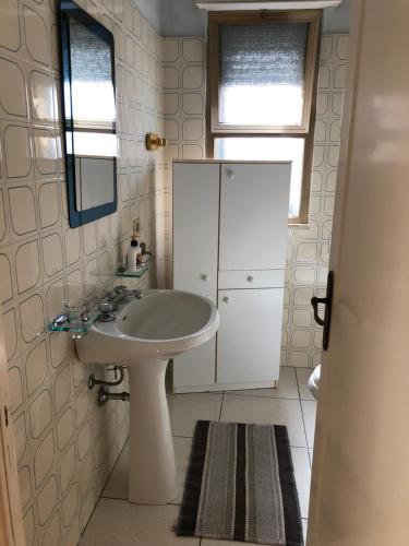 bagno con lavandino bianco e specchio di Villa Smeraldo blu a Torre Lapillo