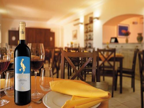 a bottle of wine sitting on a table with wine glasses at Agriturismo Sirignano Wine Resort in Sirignano