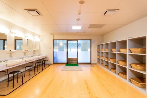 a bathroom with sinks and mirrors and shelves at Hotel Sunny Shiga in Yamanouchi