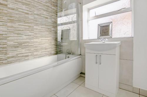 a bathroom with a sink and a bath tub and a sink at Mariners House in King's Lynn