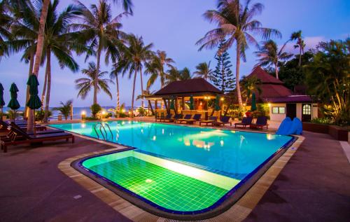 a pool at a resort with palm trees at Coco Palm Beach Resort - SHA Extra Plus in Mae Nam