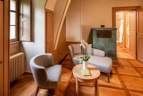 a living room with two chairs and a table at Schloss Schadau - Swiss Historic Hotel in Thun
