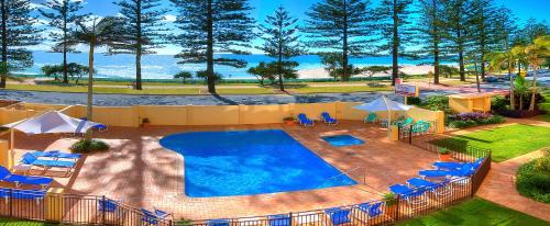 an overhead view of a swimming pool with lounge chairs at Columbia Beachfront Apartments on Rainbow Bay in Gold Coast
