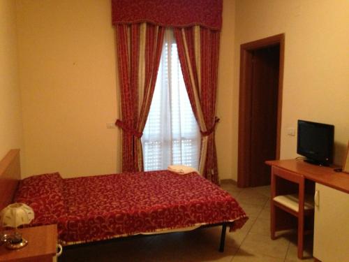 a bedroom with a red bed and a window at Affittacamere Flavia Roma in Ostia Antica